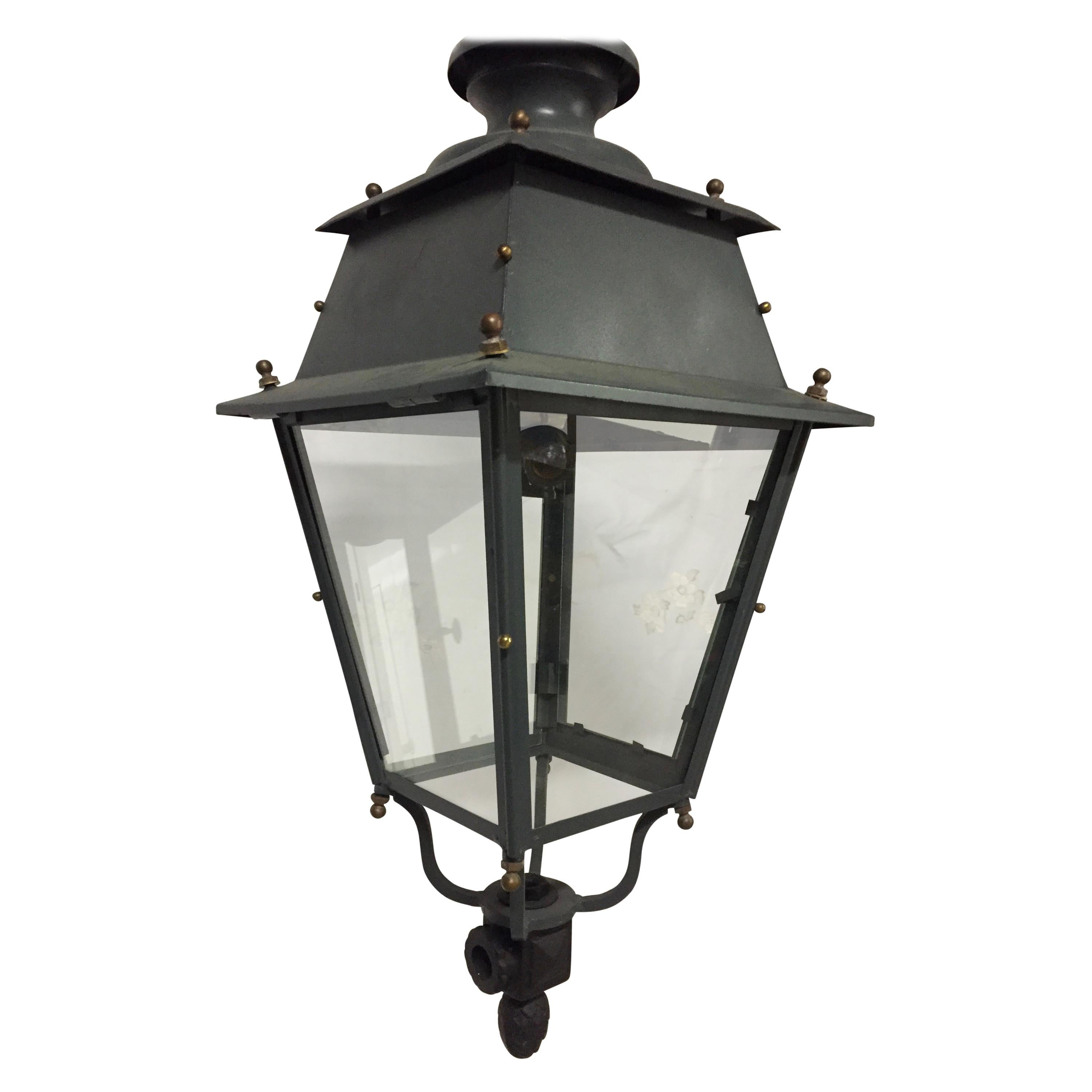 This beautiful early 20th century large Victorian style Parisian street lantern has been converted to be a gorgeous hanging light fixture. The painted iron lantern has bronze detail finials on all corners and decorating the edges. There are four