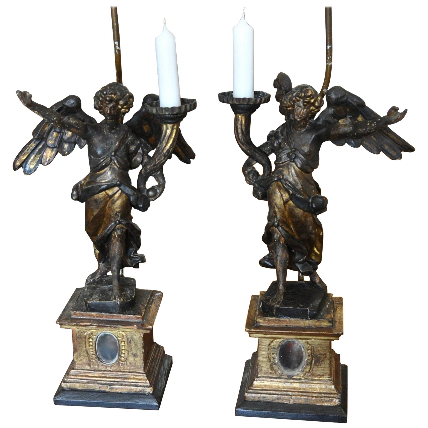 Paire de candélabres à verge italiens et reliquaires en bois sculpté et doré représentant des anges et convertis en lampes en vente