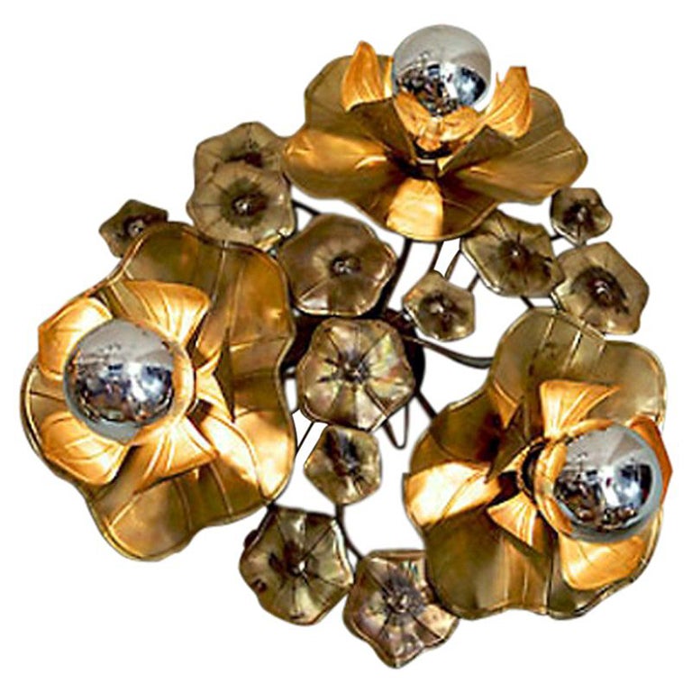 Designed by Valerie Wade and hand-crafted by artisans in solid brass in England, the lines on every leaf and petal are detailed by hand. All flowers and leaves are soldered together with silver. Silver-tipped bulbs magically reflect back onto the