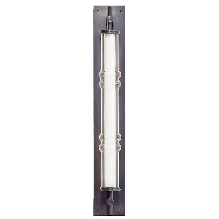 The Totem Sconce takes lighting in a more sculptural direction. The glass globe features geometric shapes which refer to those on an abacus, giving the lighting its unique form. Connected to a steel or brass back plate, the Totem Sconce is able to
