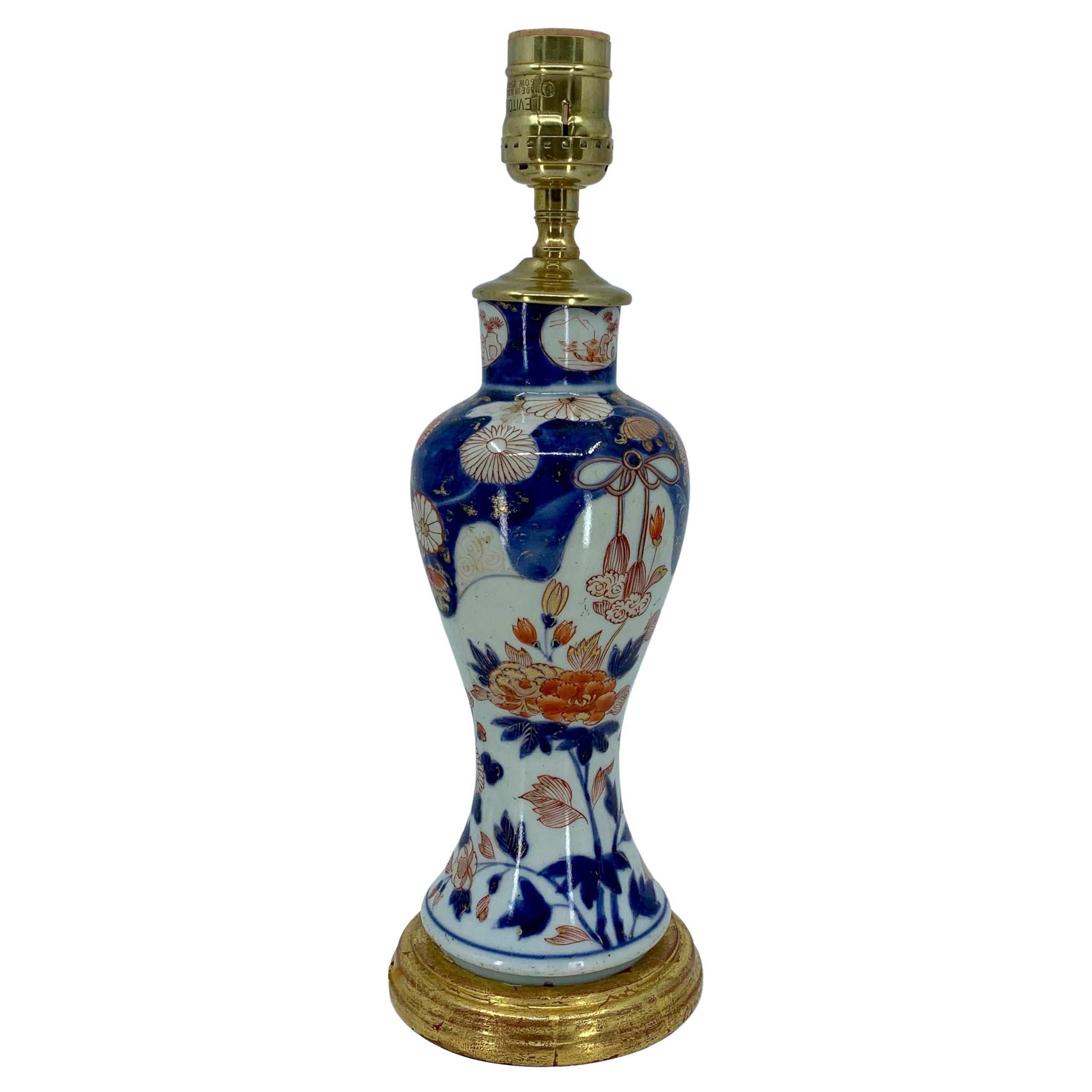 Lampe en porcelaine bleue, blanche, rouge et dorée sur base en bois doré en vente