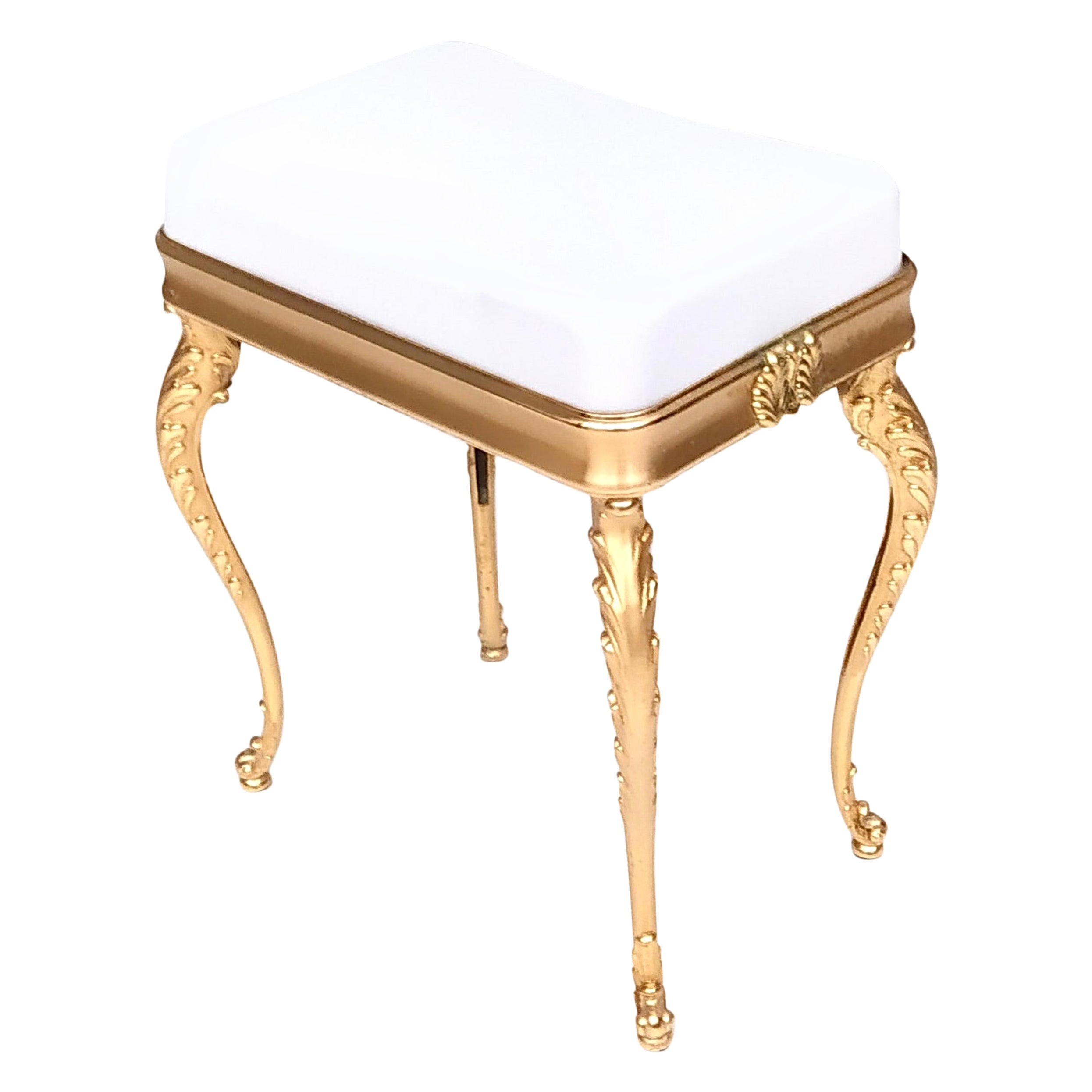 Made in Italy, 1950s.
This ottoman features a white plastic material seat and gilded cast brass legs. 
It may show slight traces of use like the slight traces of oxidation on brass that haven't been removed not to damage the beautiful