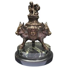 Antique 20th Century Italian Bronze Inkwell with Bull Heads and Putti Embracing Lion