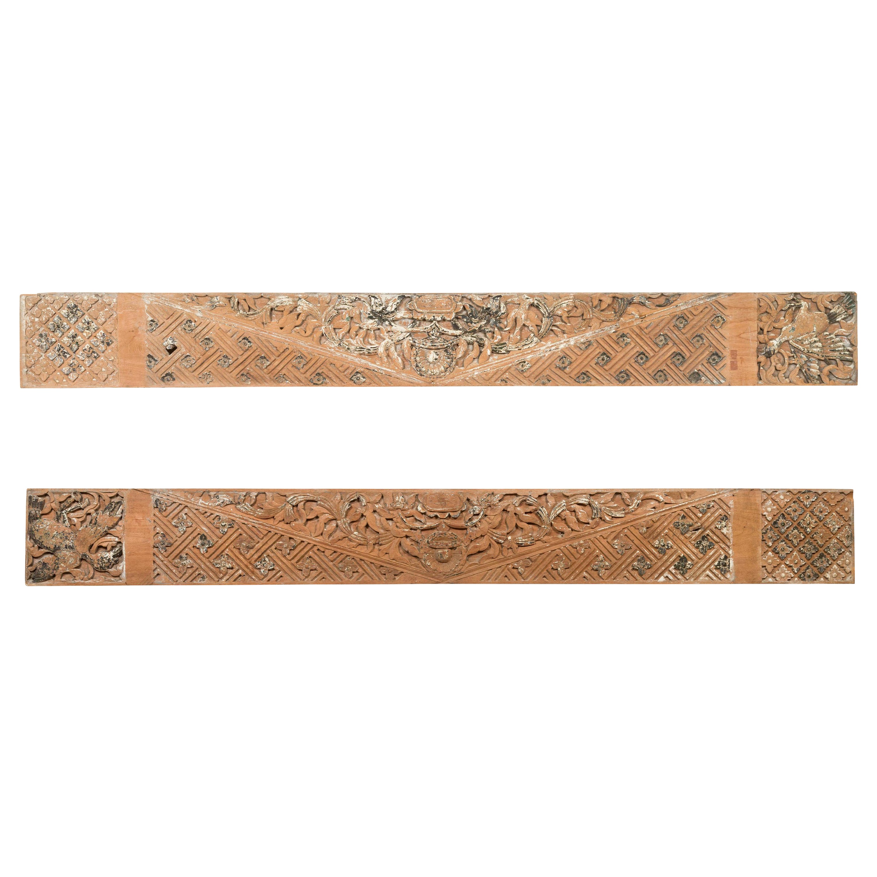 Coppia di pannelli architettonici antichi con intagli floreali e tracce di vernice originale