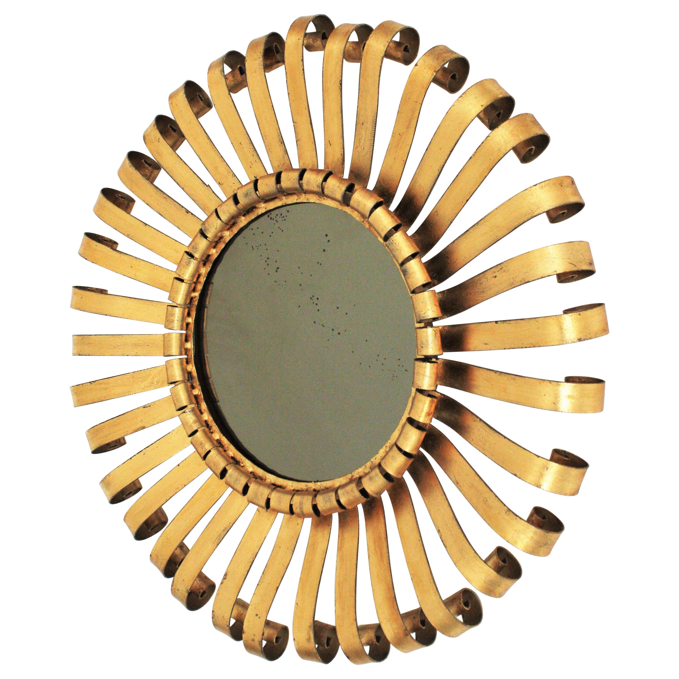 Brutalist scroll work wrought iron sunburst mirror, Spain, 1960s.
This handcrafted iron mirror has a hand forged iron structure with scroll ended beams finished in gold leaf gilding. A master piece entirely made by hand. 
It will be beautiful placed