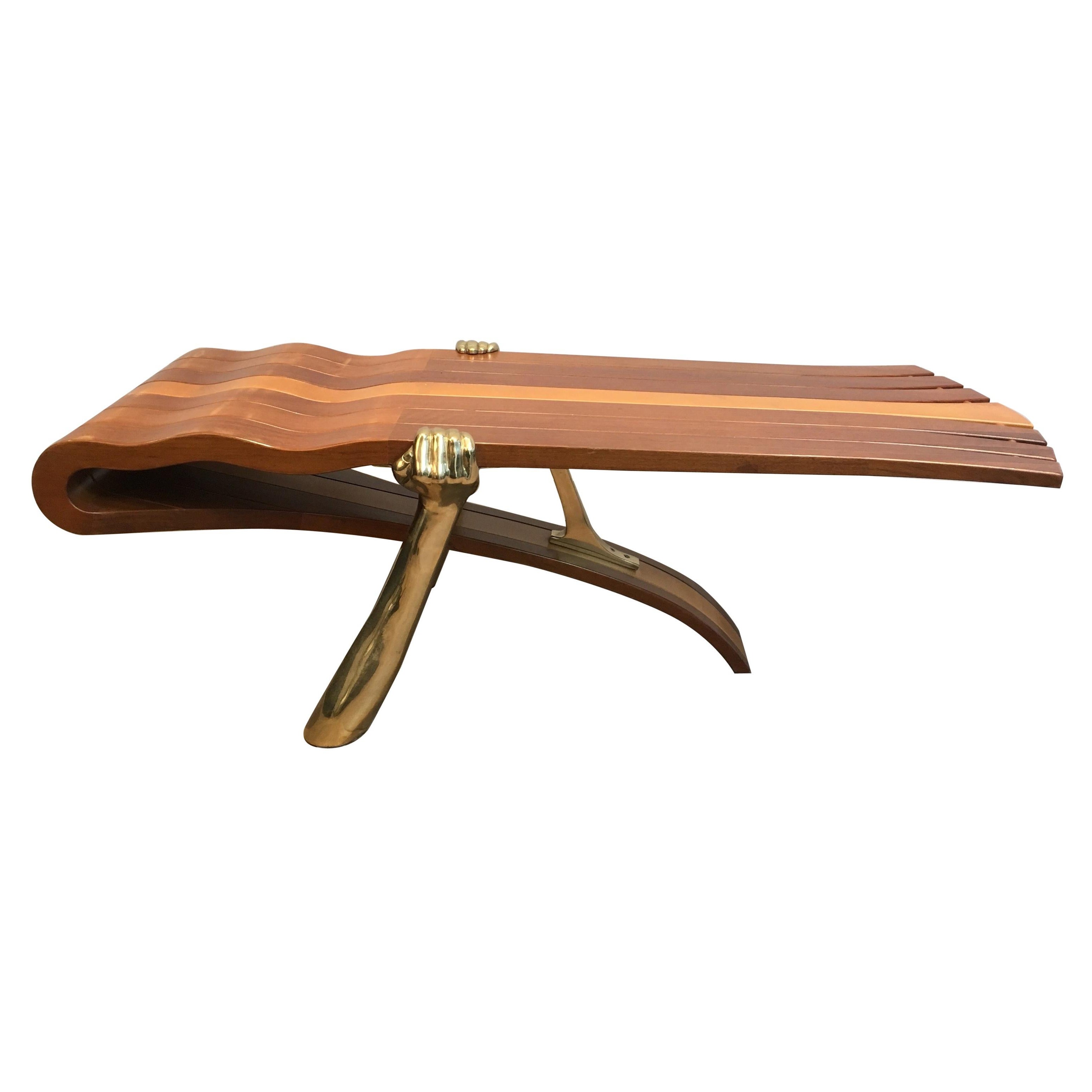 Table basse unique composée d'un plateau en bois épais de forme libre soutenu par des bras en laiton en vente