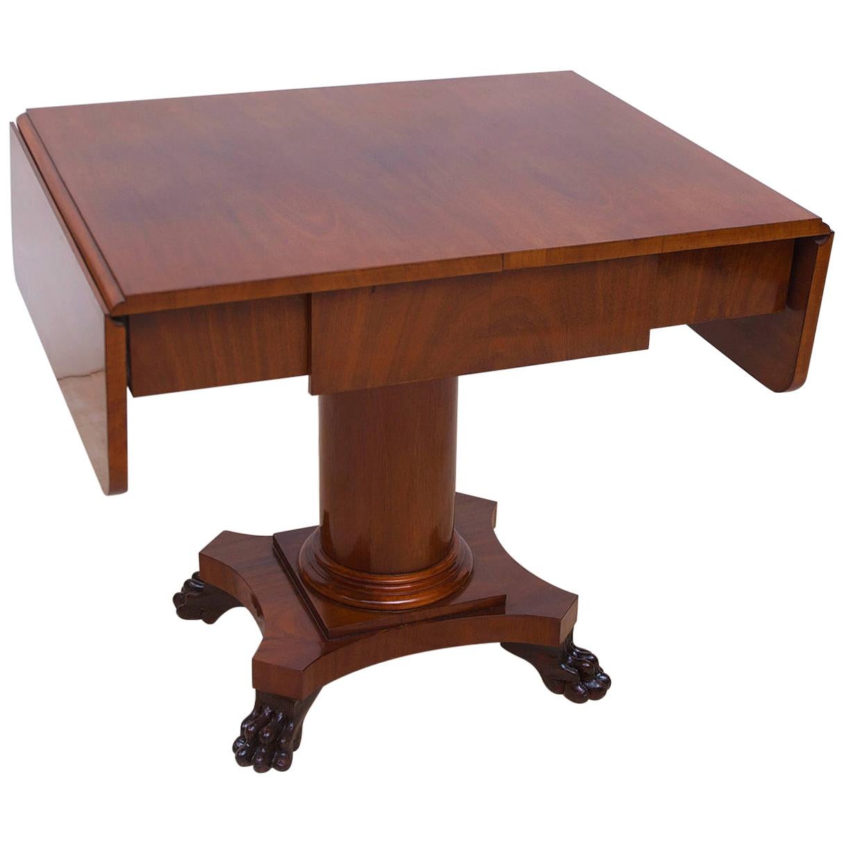 A handsome Biedermeier sofa table or writing desk in Cuban mahogany with one drawer and two drop leaves on cylinder column resting on quatre-form base with carved lions' paw feet, Sweden, circa 1840-1850.
Note: You should always request a shipping