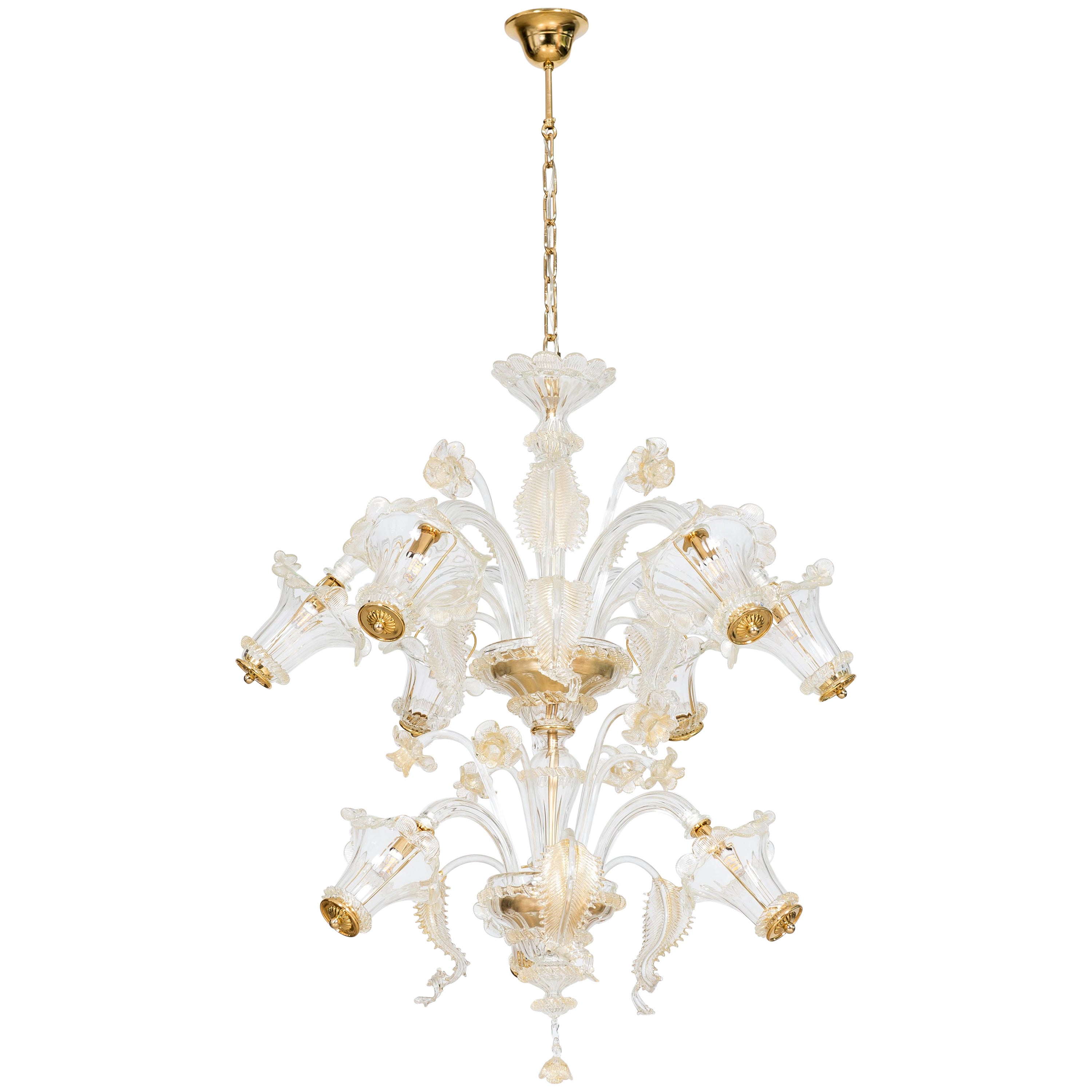 Golden Murano glass chandelier with 9 lights, 21st century, Italy.
This unique chandelier stands out for its beauty, elegance, and the refinement of its details. 
Two refined gardens of transparent and gold-finished leaves and flowers, placed at two