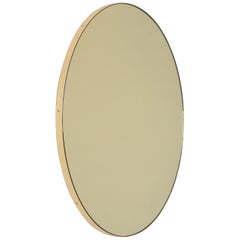 Miroir contemporain rond Orbis teinté d'or avec cadre en laiton, moyen