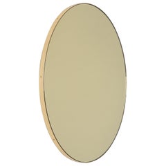 Miroir rond minimaliste orbis teinté or avec cadre en laiton, standard