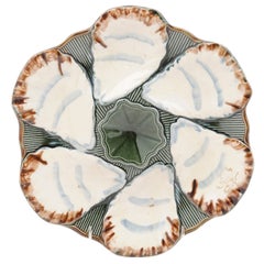 Assiette à huîtres Longchamp Terre de Fer en faïence émaillée des années 1890:: avec fleur