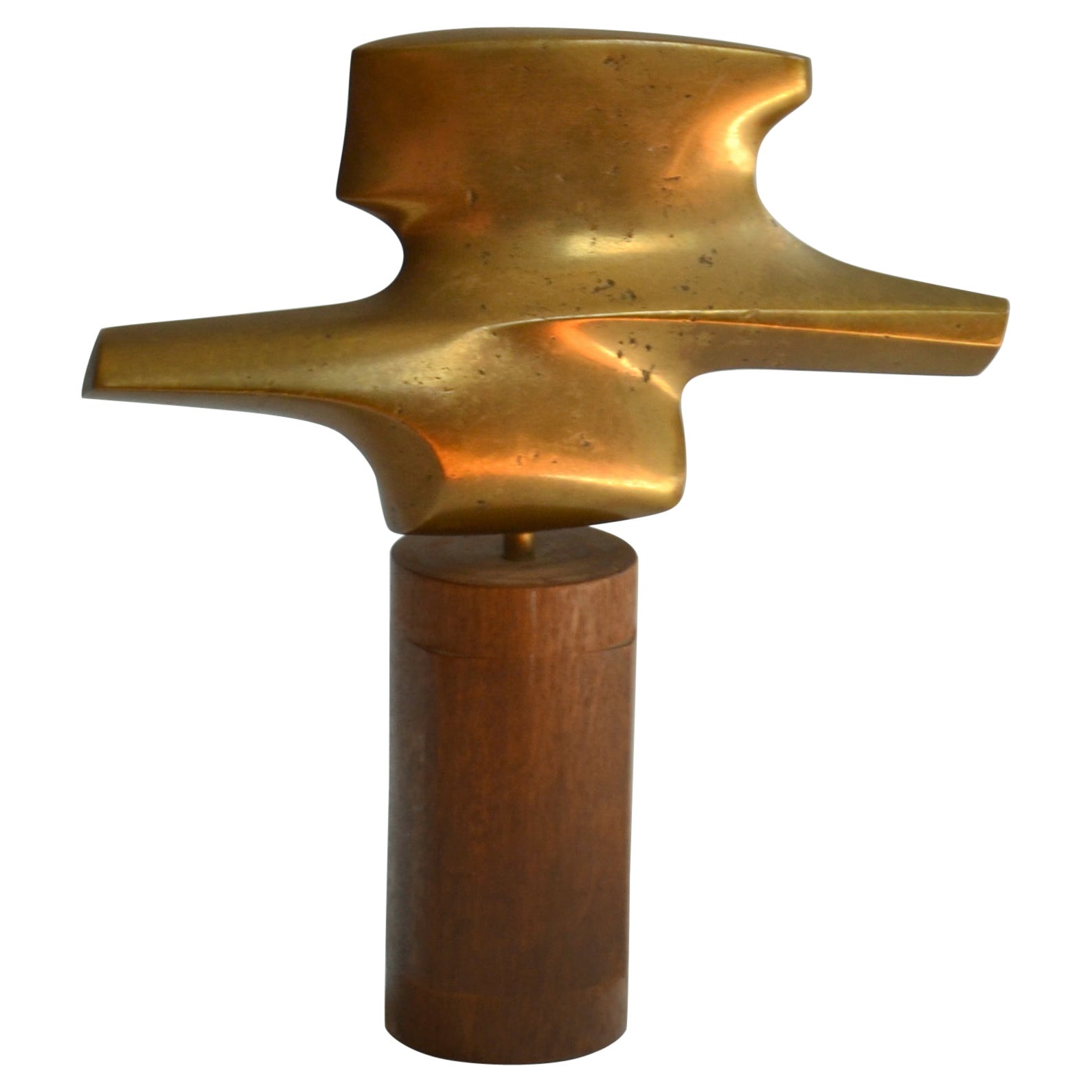 Abstract bronze cast sculpture on teak pedestal suggesting a bird in flight. The aerodynamic form gives the impression of sustaining flight around the gleaming gold surface of this abstract expression.
Abstract bronze cast sculpture Dutch 1970's is