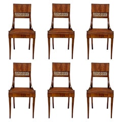 Ensemble de six chaises raffinées et rares de style Klismos en noyer avec assise en rotin