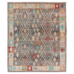 Alfombra moderna de diseño tribal y diamantes con fondo gris y colores vivos