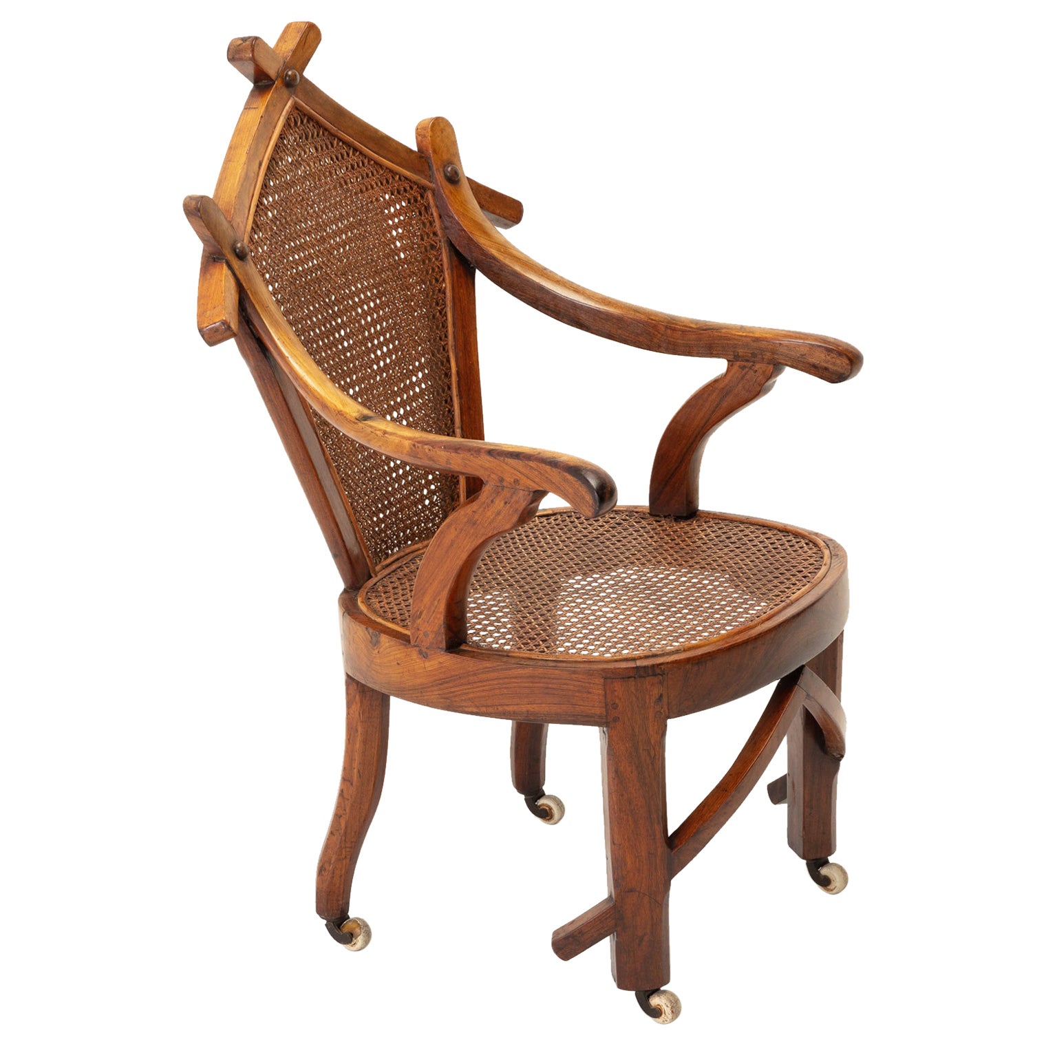 A very unusual and stylish 19th century walnut and cane chair, featuring an uncommon top rail of crossed pieces of walnut with arms attached by round head rivets. Both seat and back are fitted with handwoven cane.

In excellent condition with a
