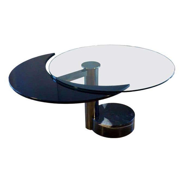 Sculptural dining table revolves in two positions from round to oval. This most extraordinary table is made with high quality materials and engineering, avantgarde design typical from the 1980's. When the black lacquered moon shape part of the table