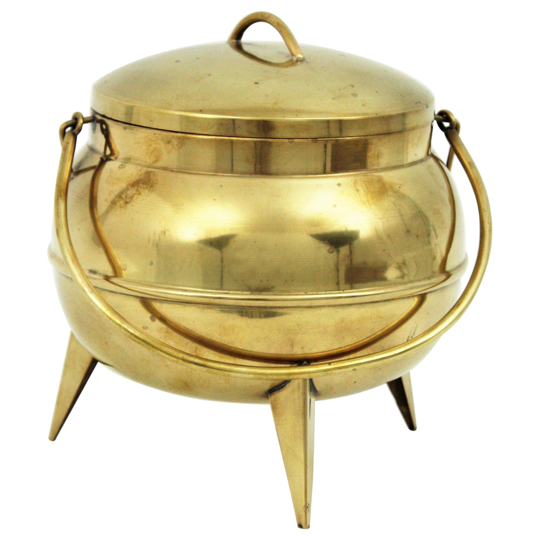 Mid-Century Modern Kitchen Pot Cauldron Tripod Eiskübel oder Weinkühler, Messing. Spanien, 1950er Jahre.
Er steht auf einem dreibeinigen Sockel und hat einen klappbaren Griff und Deckel.
Dieser coole Eiskübel mit Küchentopf-Design ist ein cooler