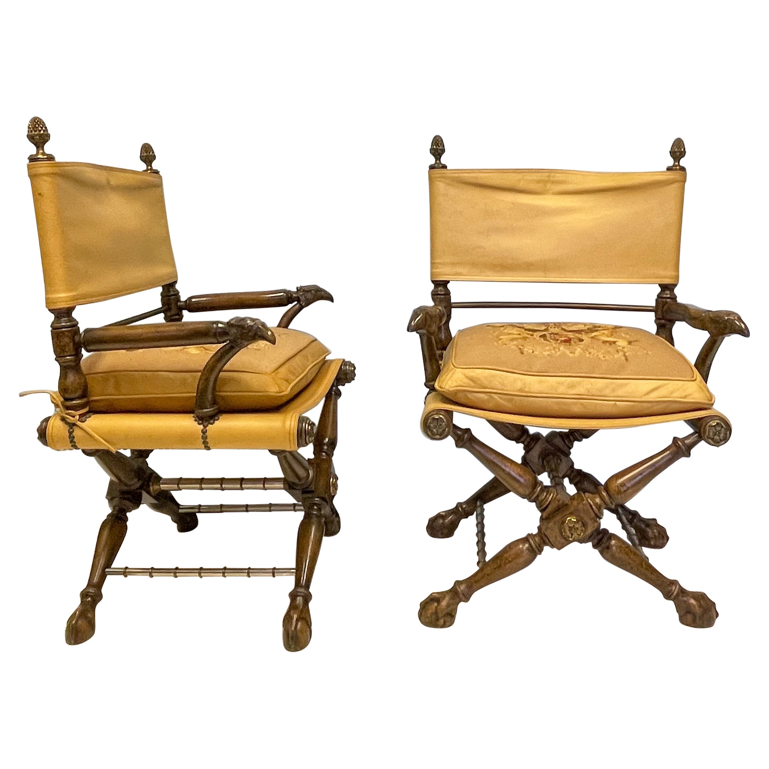 This is unique pair of leather Regency and campaign style carved eagle chairs attributed to Theodore Alexander. They have heraldic needed point cushions and steel and brass cross stretchers. They are unmarked. The leather shows some age wear. 
  