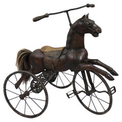 Cheval en bois sculpté sur tricycle, début du 20e siècle