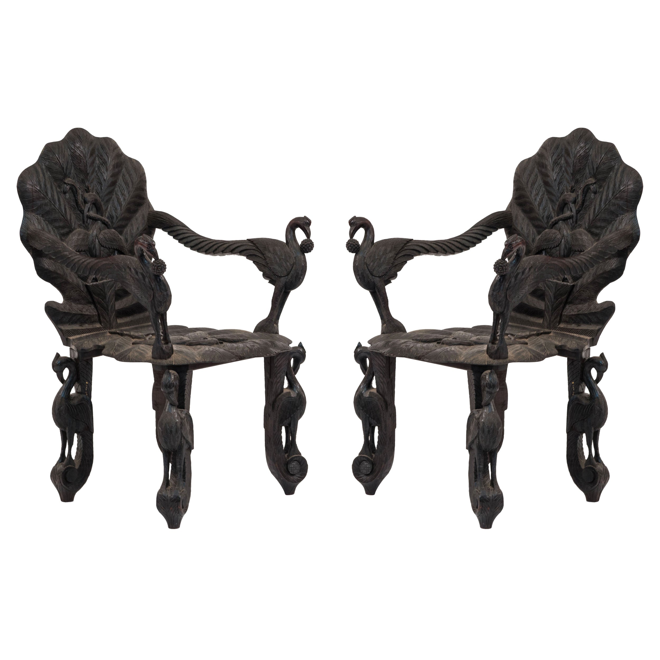 Pair of Burmese Ebonized Carved Leaf and Bird Design Armchairs