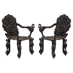 Pair of Burmese Ebonized Carved Leaf and Bird Design Armchairs