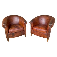 Pair Distressed Vintage European Leather Tub Chairs with Brass Nailhead Detail