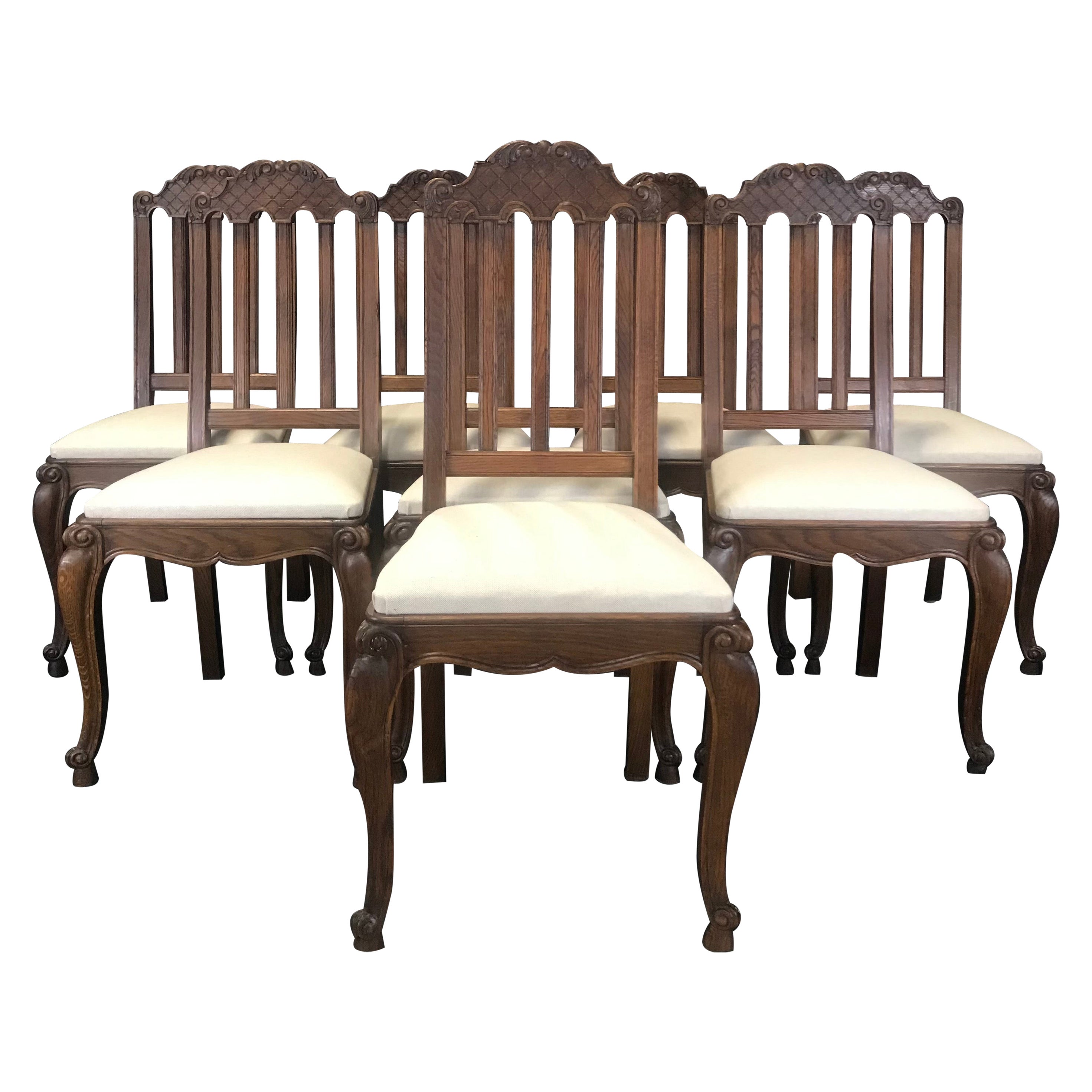 Set of Eight French Oak Intricately Carved Louis XV Chairs with Snail Feet