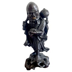 Figure chinoise du 19e siècle en bois dur sculpté représentant un immortel tenant une batte