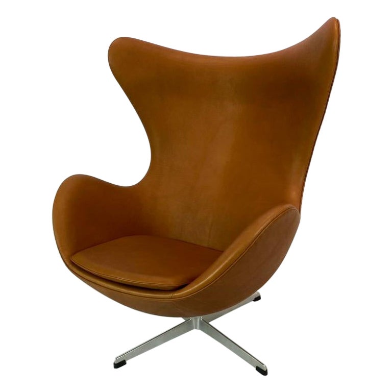 The Egg, model 3316 designed by Arne Jacobsen in 1958 and manufactured by Fritz Hansen. The chair is upholstered in cognac colored patinated leather and is in great condition. Arne Jacobsen created the Egg back in 1958 as part of a project for the