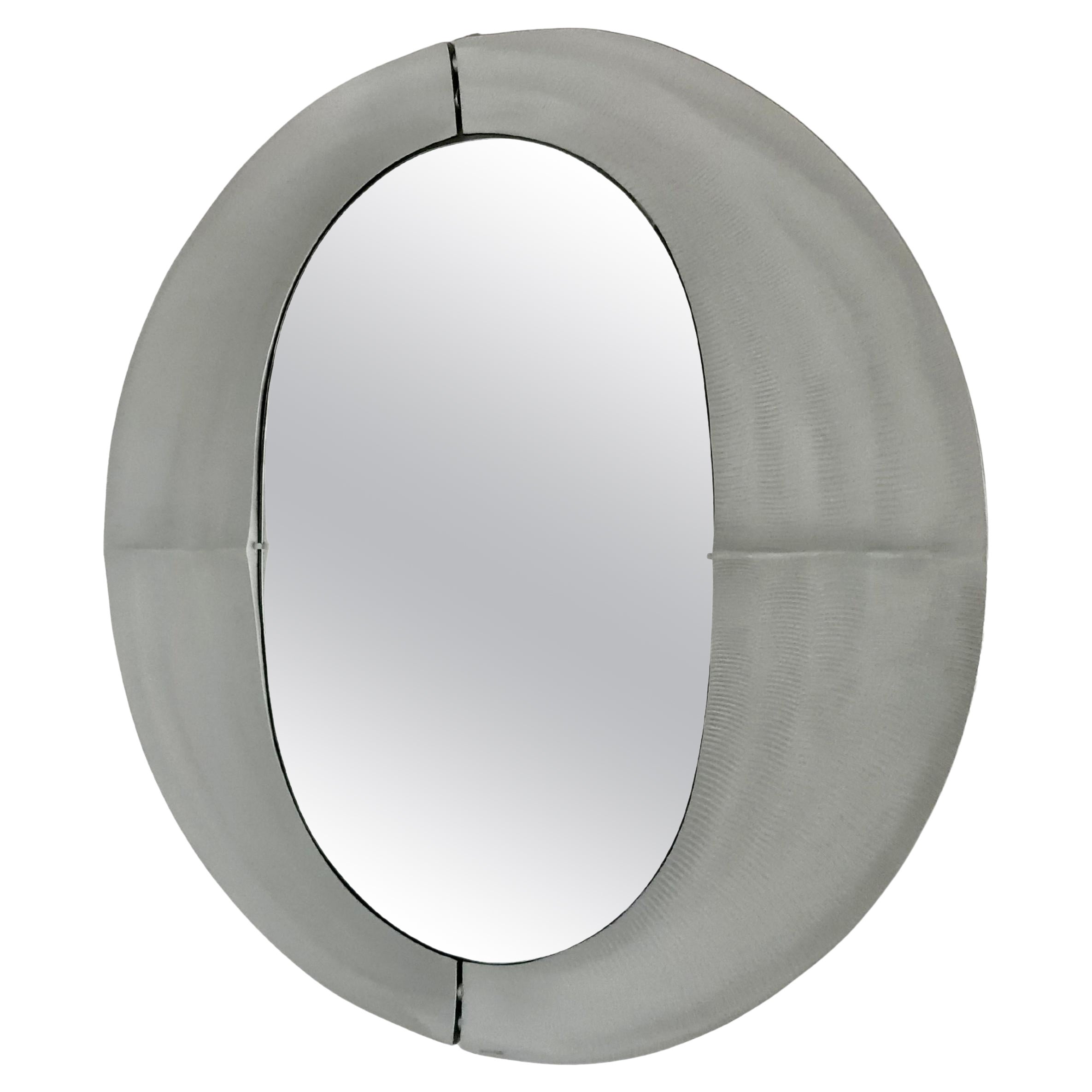 A sculptural modernist round mirror by artist Lorenzo Burchiellaro from the 1970s. Textured cast aluminum with a slightly concave shape. Signed on the bottom Burchiellaro.