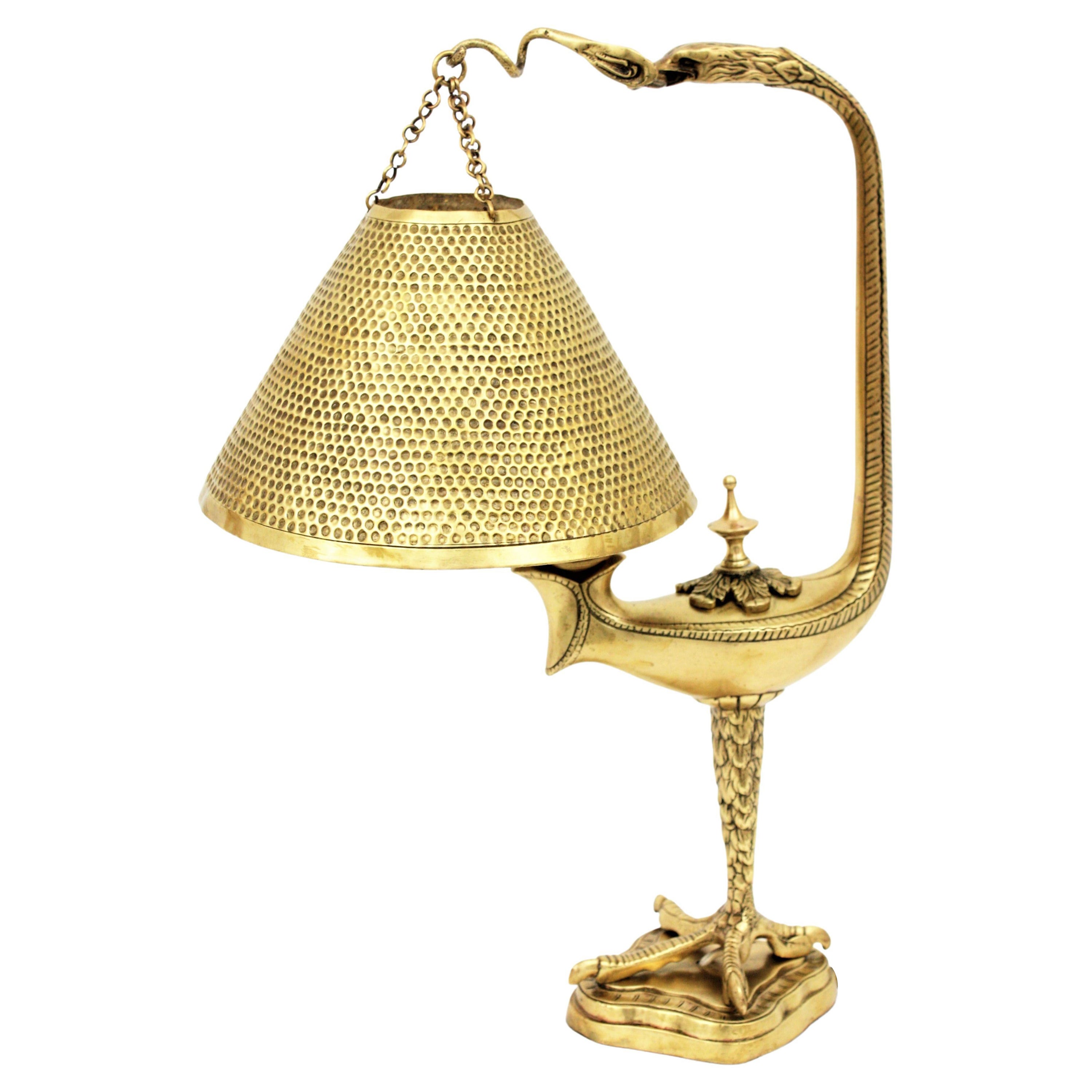 Art Deco desk lamp bird design, brass and brass Repoussé. France, 1920-1930s.
Solid brass desk lamp or table lamp featuring an eagle figure with a brass repoussé shade hanging from its beak. 
This unique table lamp features a gorgeous cast and
