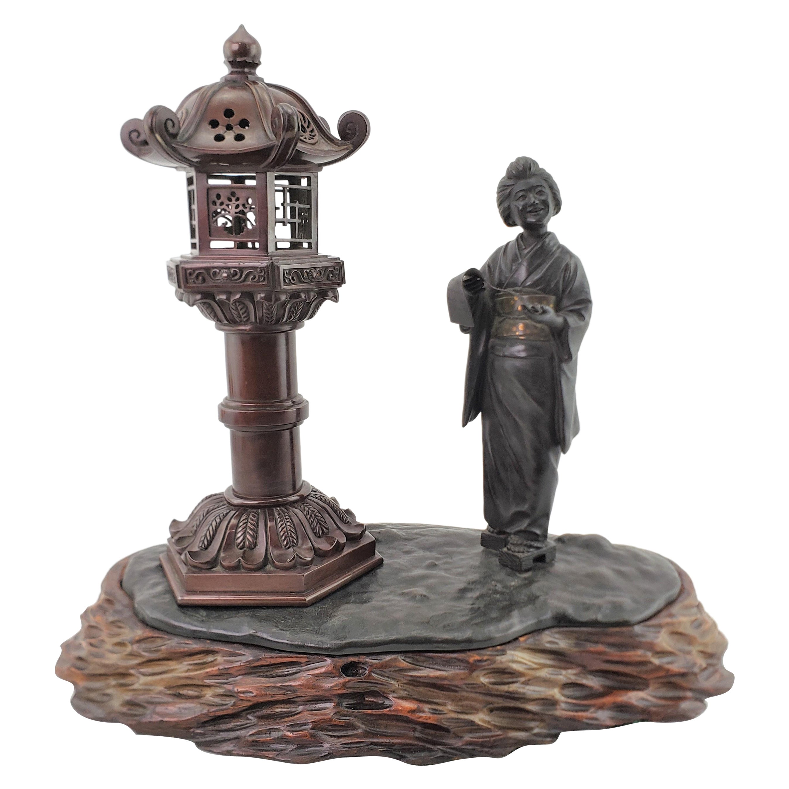 Brûleur d'encens ancien japonais figuratif représentant une femme et une lanterne, signé Meiji, avec base