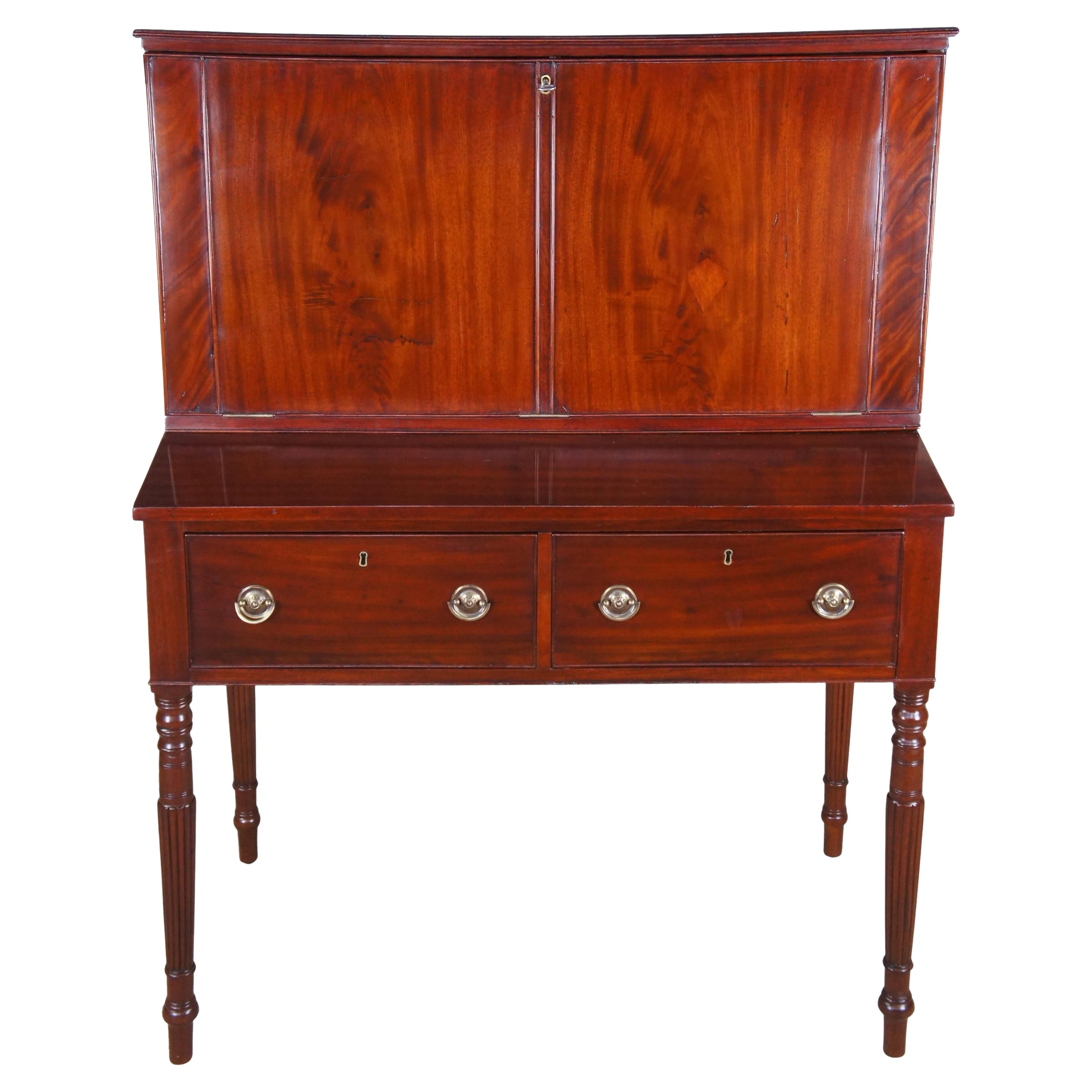 An exquisite and rare late 18th century American Federal Sheraton library secretary desk. Made of mahogany featuring velvet drop front writing surface that leads to multiple cubbies / compartments / cabinets (and one hidden), two large drawers with