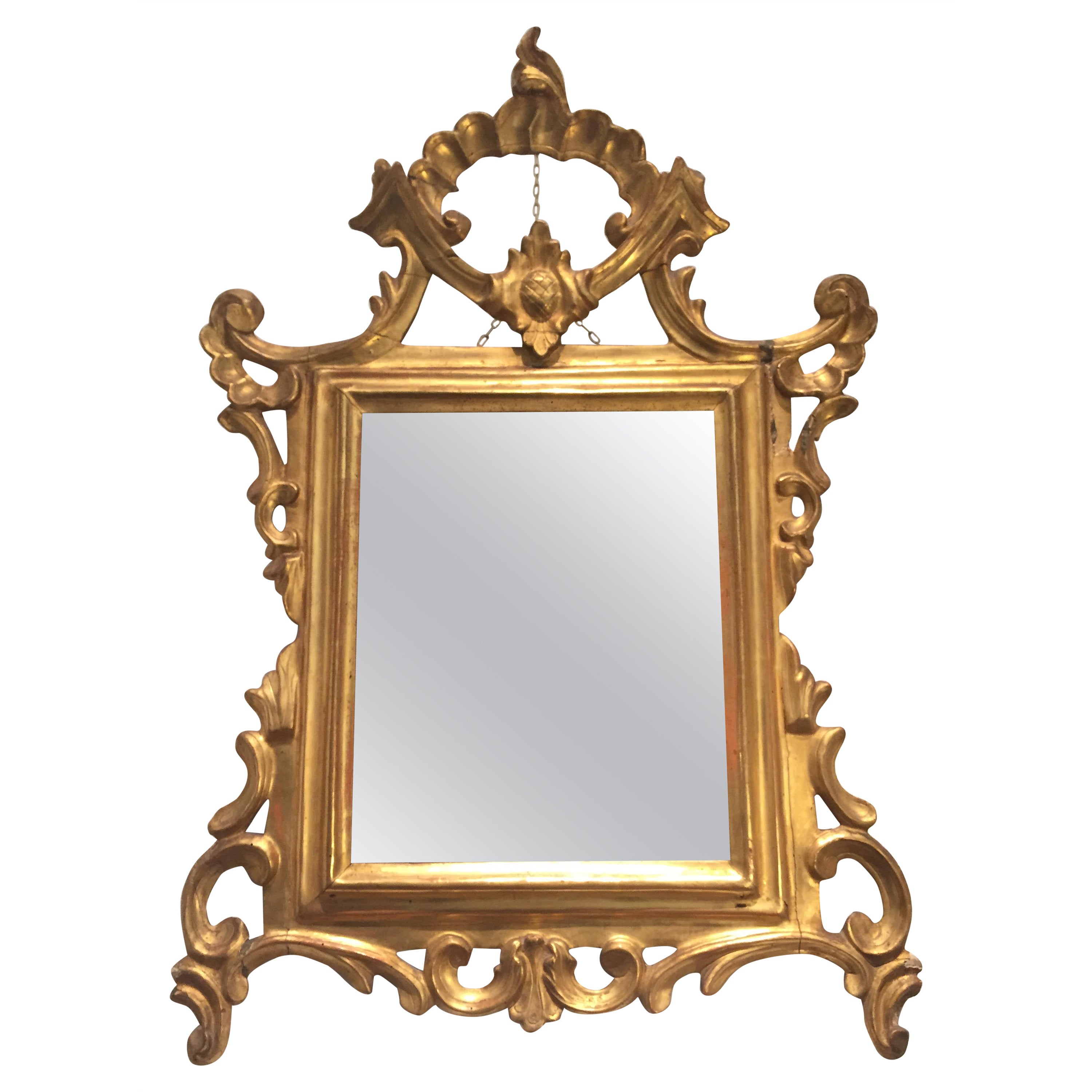 An Italian Louis XV carved and gilt wood mirror dating back to the mid-18th century. Of Italian origin, this antique mirror is realized in Cembran pinewood and comes from the furnishing of a private collection in Milan. 

Original gilding and