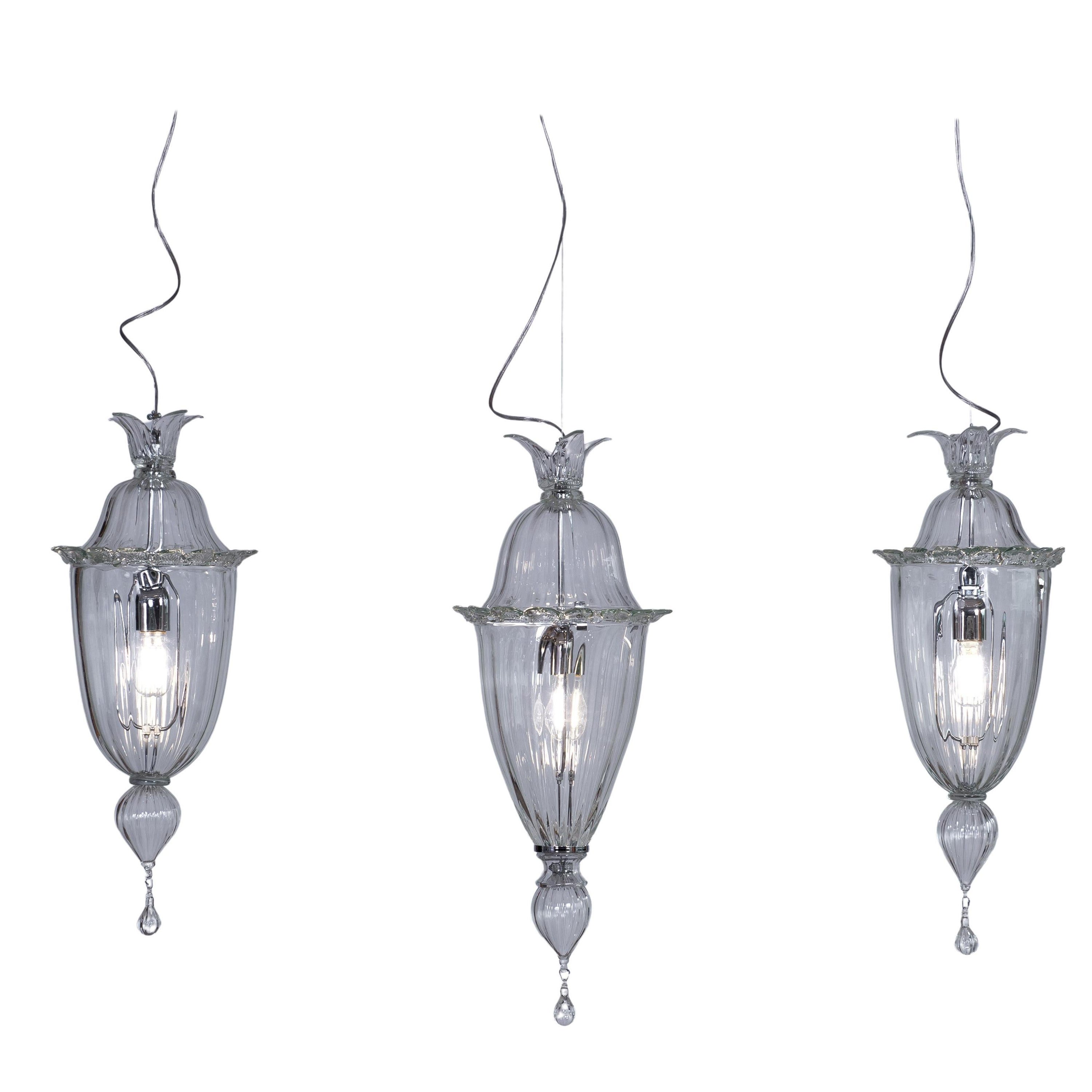 Cesendelli chandelier in transparent Murano glass modern Italy.
The chandelier holds three transparent cesendelli made of Murano glass, set at two different heights and fixed to the ceiling thanks to a 51.20 inch-long chromed rod. The cesendelli