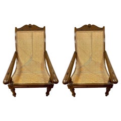 Pair of Matching British Colonial Cane Plantation Chairs with Pullout Leg Rests