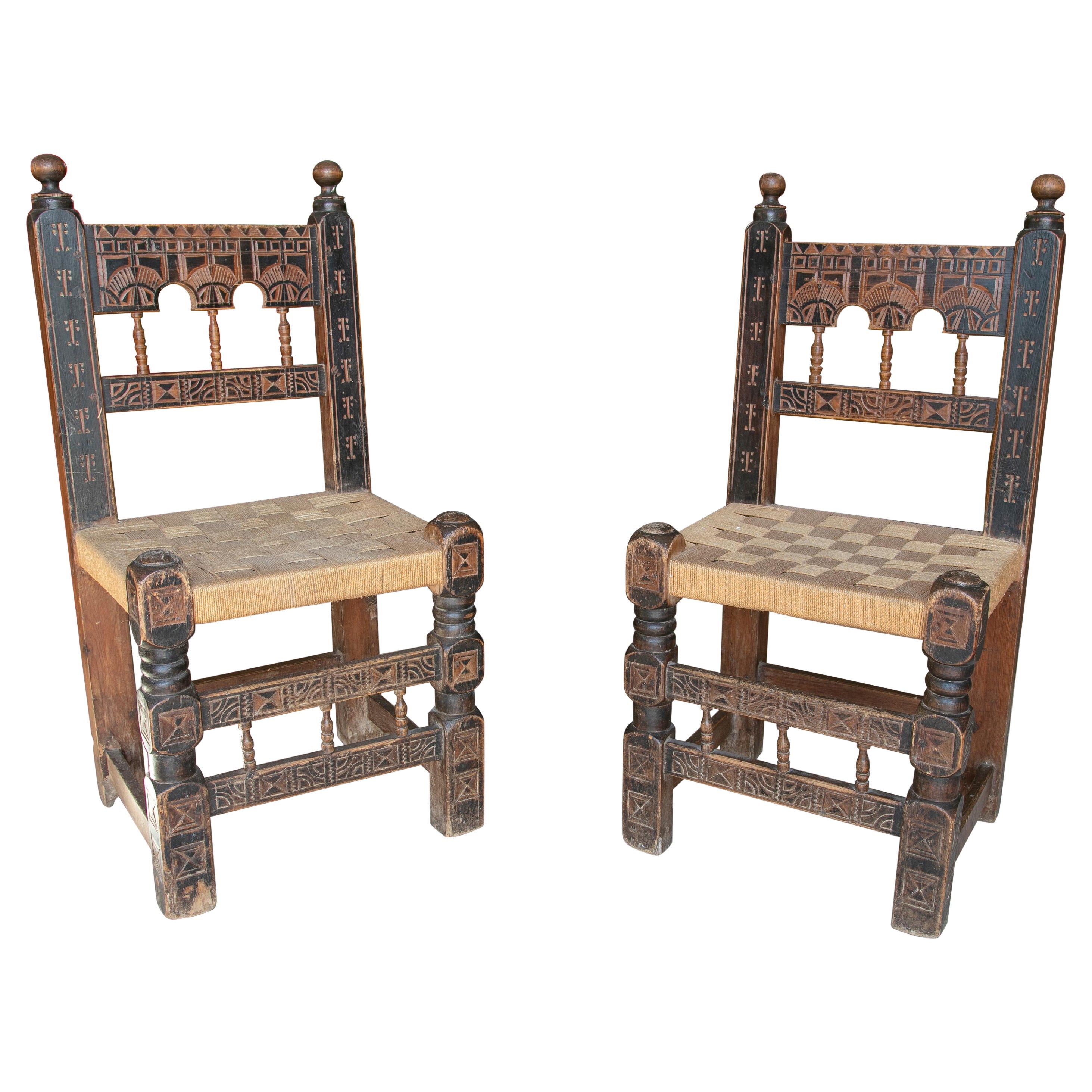 Paar spanische handgeschnitzte bemalte Holzstühle aus den 1920er Jahren mit geflochtenen Binsen-Sitzen