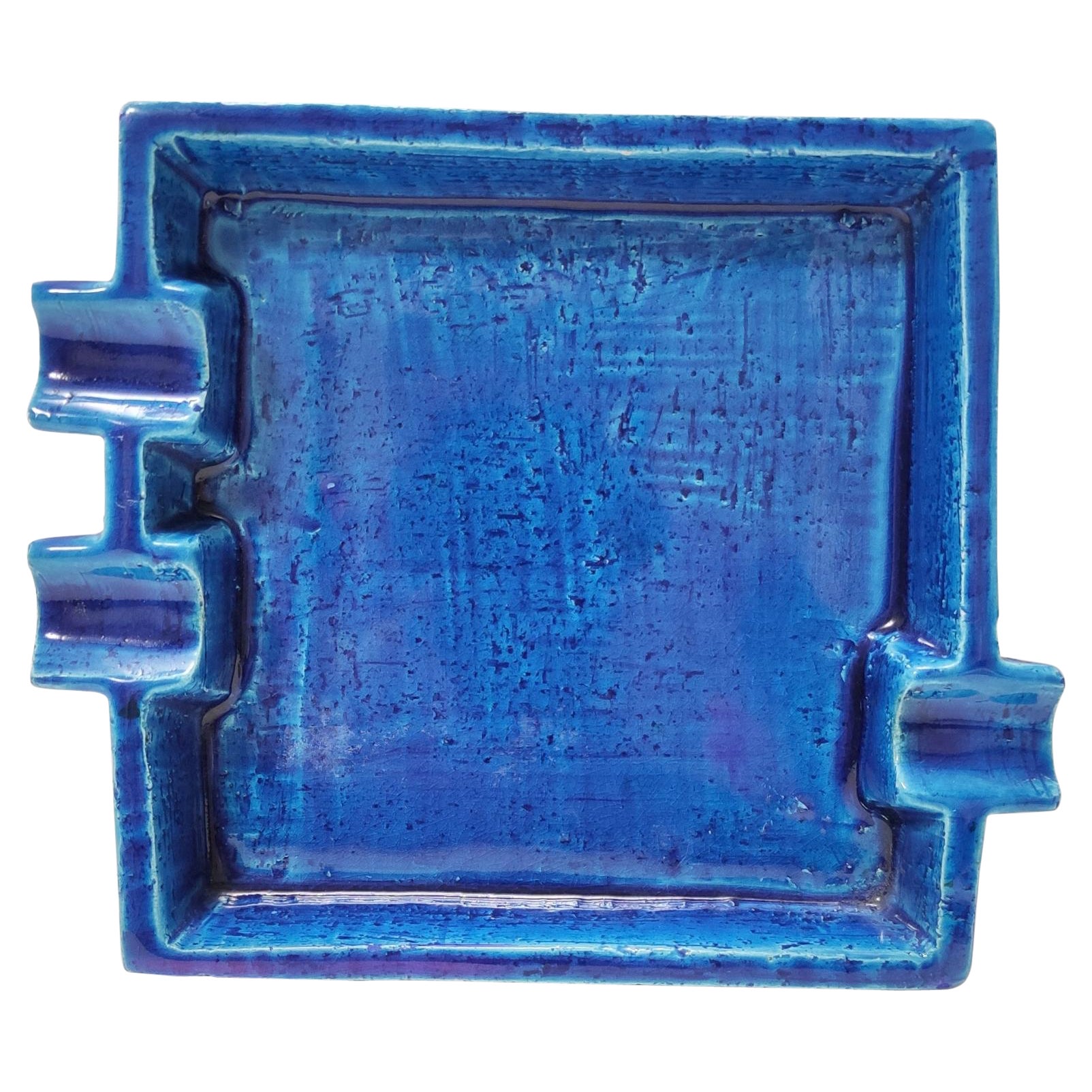Made in Italy, 1960s.
This ashtray, designed by Aldo Londi and manufactured by Bitossi, is made in Rimini blue glazed ceramic and features 3 cigar or cigarette holders. 
It is a vintage piece, therefore it might show slight traces of use, but it