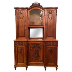 Ancienne armoire française en noyer sculpté, verre biseauté et miroir, vers 1875-1895