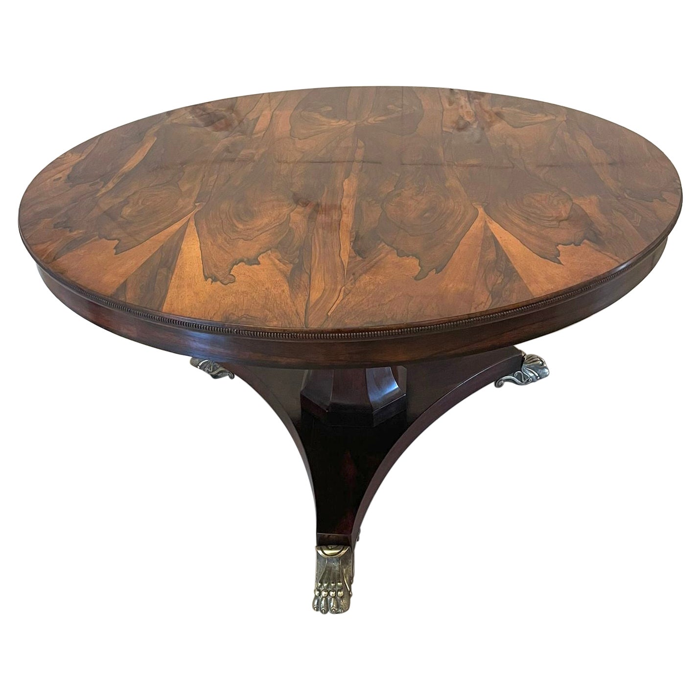 Outstanding quality antique Regency rosewood circular centre table with bronze feet having an magnificent quality circular rosewood tilt top centre table with a beaded edge supported by a hexagonal shaped pedestal column and standing on a shaped