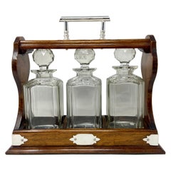 Tantale anglais ancien de 3 bouteilles en chêne et cristal monté sur métal argenté, vers 1880