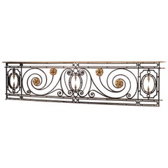 Longue grille de balcon parisienne en fer forgé du 19ème siècle avec rehaut en bronze doré