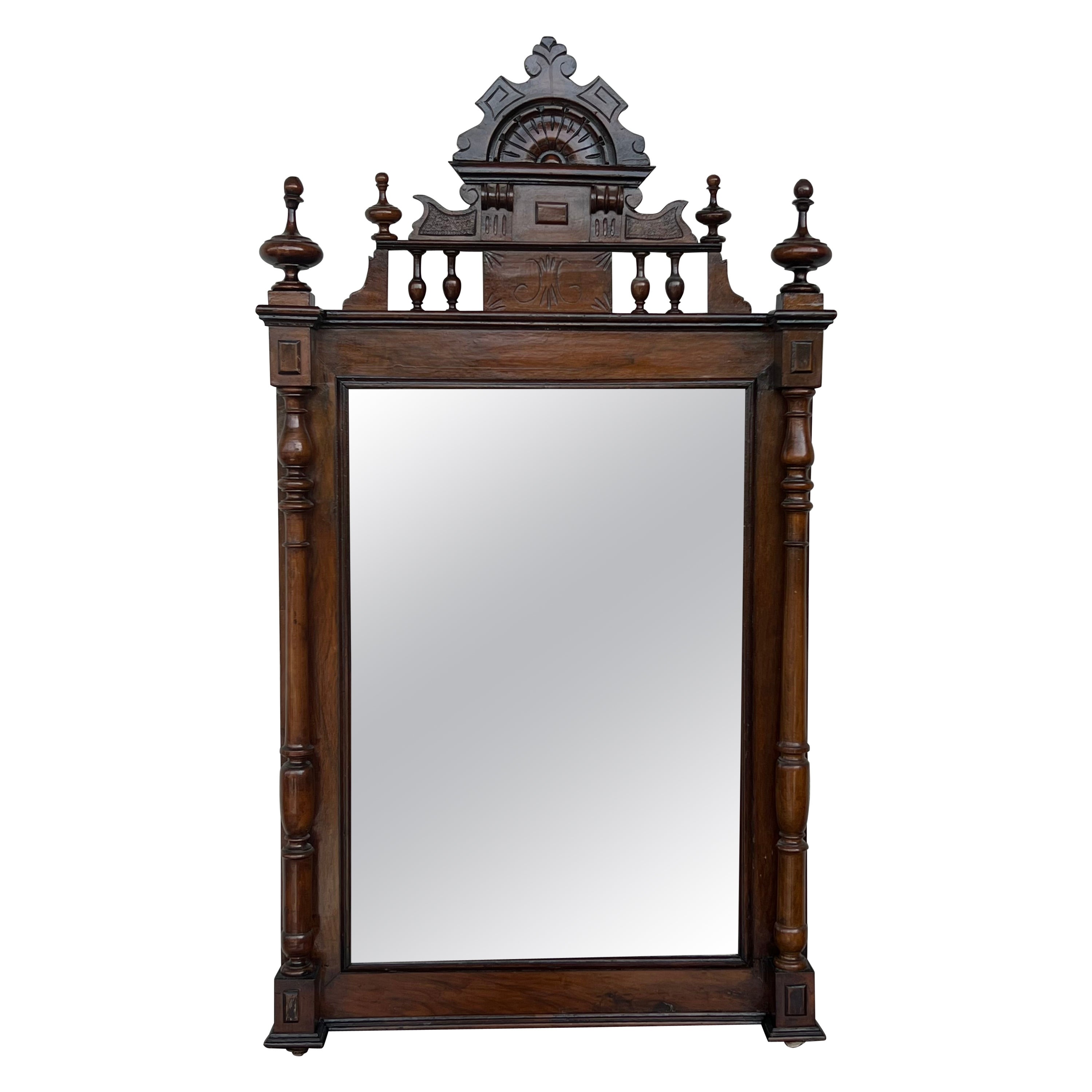 Early 20th French Ebonized Mirror with Turned Columns and High Carved Details For Sale