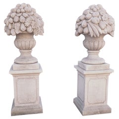 Pair of Italian Limestone Urns with Fruit and Floral Bouquets on Pedestals