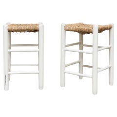 Paar weiße Hocker im Charlotte Perriand-Stil mit niedriger Thekenhöhe und Binsen-Sitzen