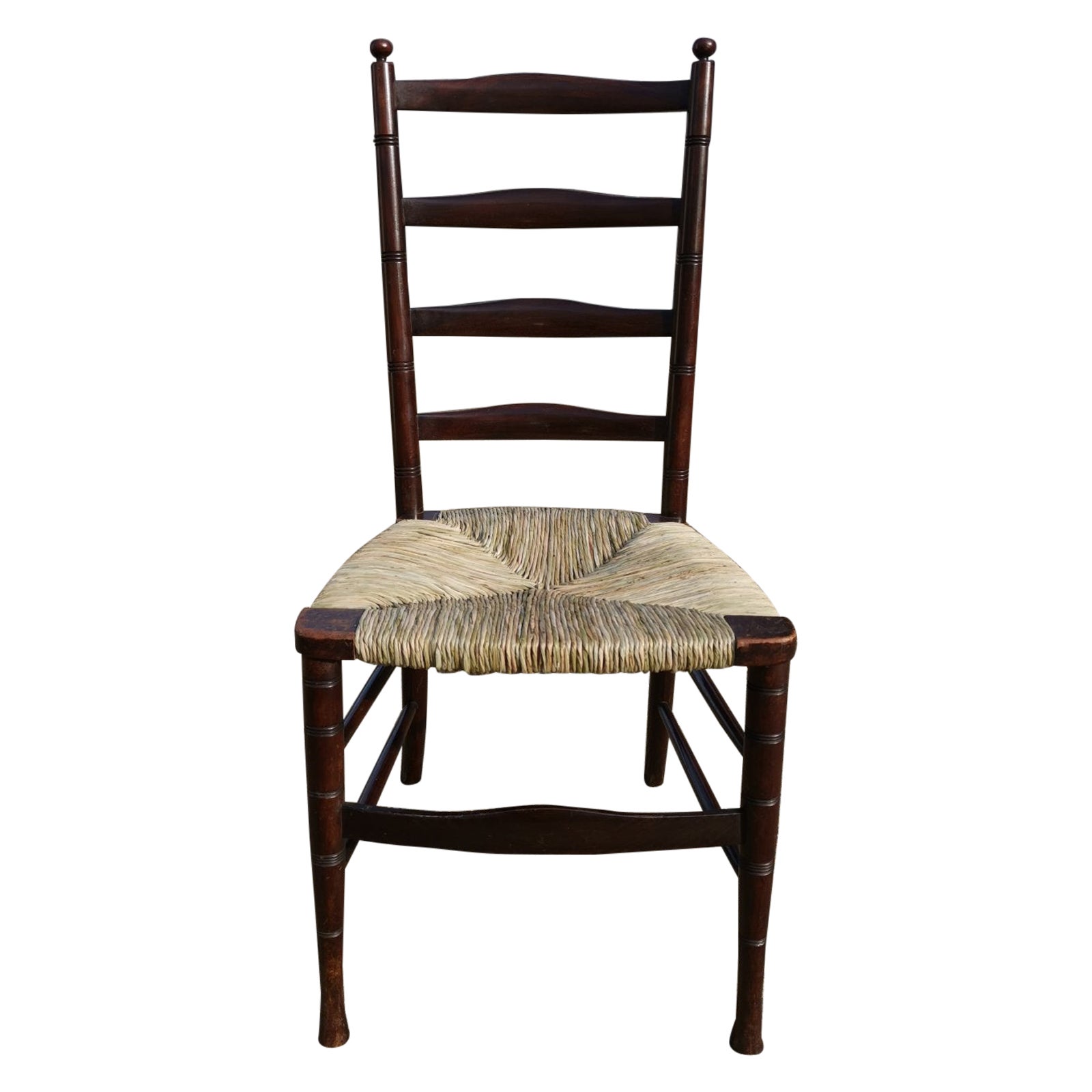 Liberty and Co. London. 
An elegant English Aesthetic Movement walnut ladder back side chair. 
The last three images are from: A Pictorial Dictionary of British 19th Century Furniture Design. They show slight variations in this design.
With