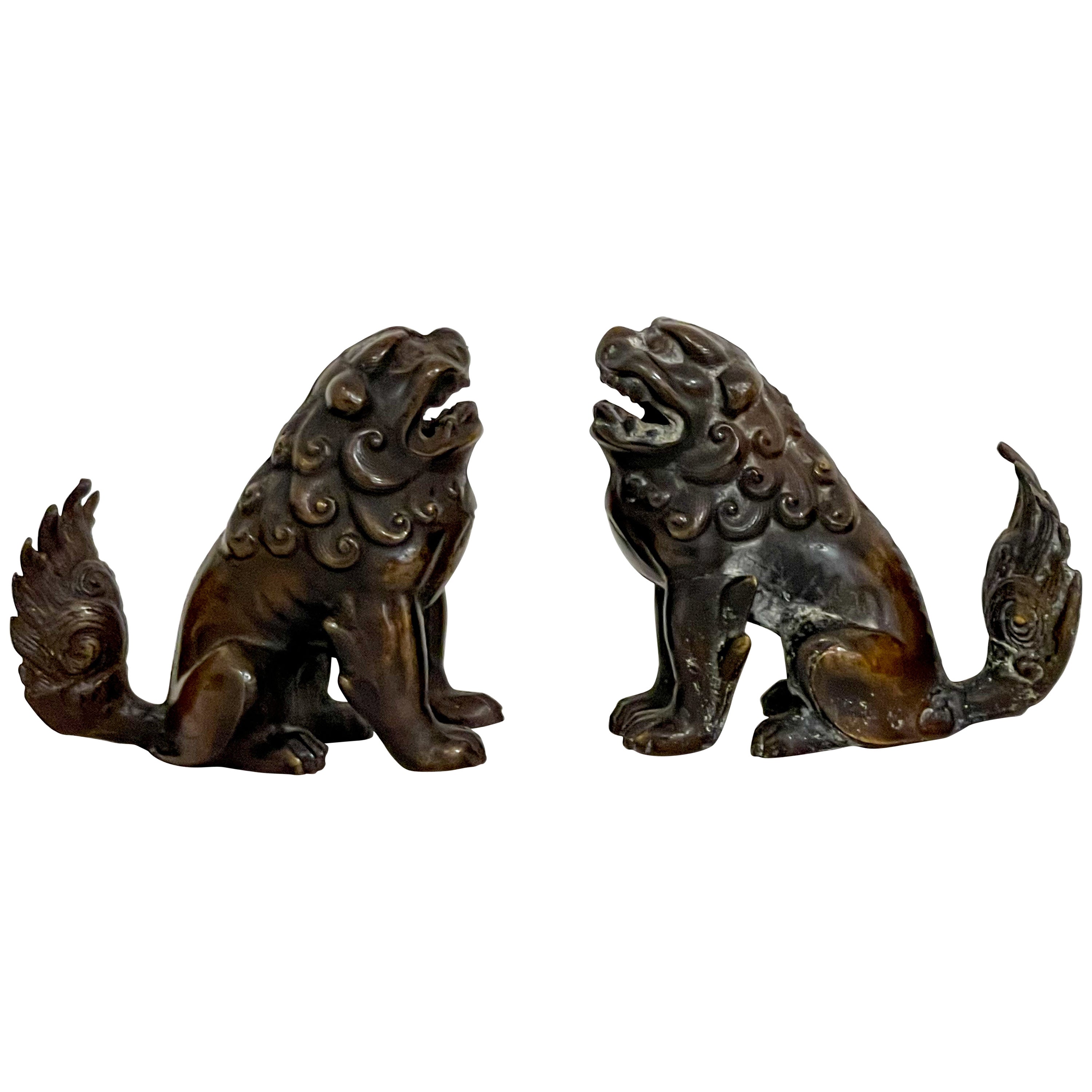 Début du 20e siècle. Paire de figurines asiatiques en bronze représentant des chiens ou des lions en guise de nourriture