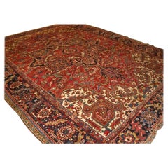 Tapis Heriz ancien avec grand médaillon sur terrain rouge moutarde