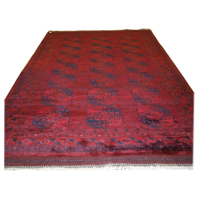 Alter roter afghanischer Teppich mit traditionellem Design