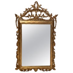 Miroir en bois sculpté et doré de style Louis XVI